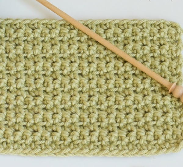 Image shows a sage green swatch made of back and front single crochet stitch. There's a light wood crochet hook sitting on top. Image shows a sage green swatch made of back and front single crochet stitch. There's a light wood crochet hook sitting on top.