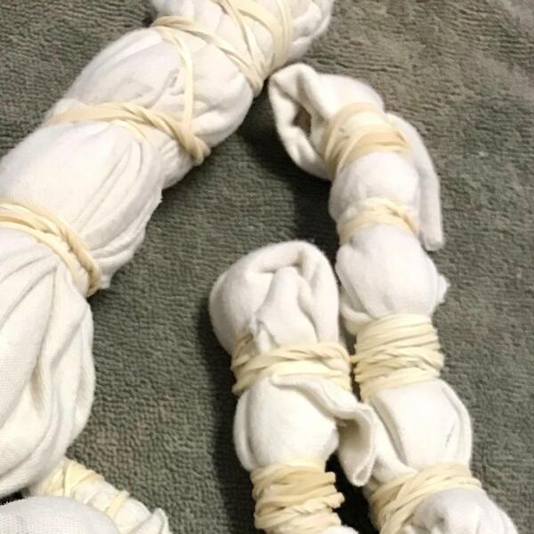 Wrap rubber bands tightly around the bundled fabric at intervals. Wrap rubber bands tightly around the bundled fabric at intervals.